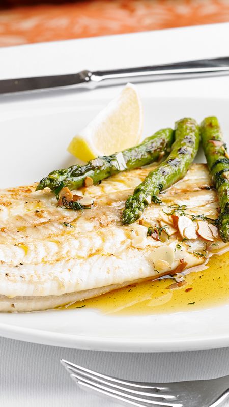 A fillet of grilled sea bass garnished aromatic herbs.